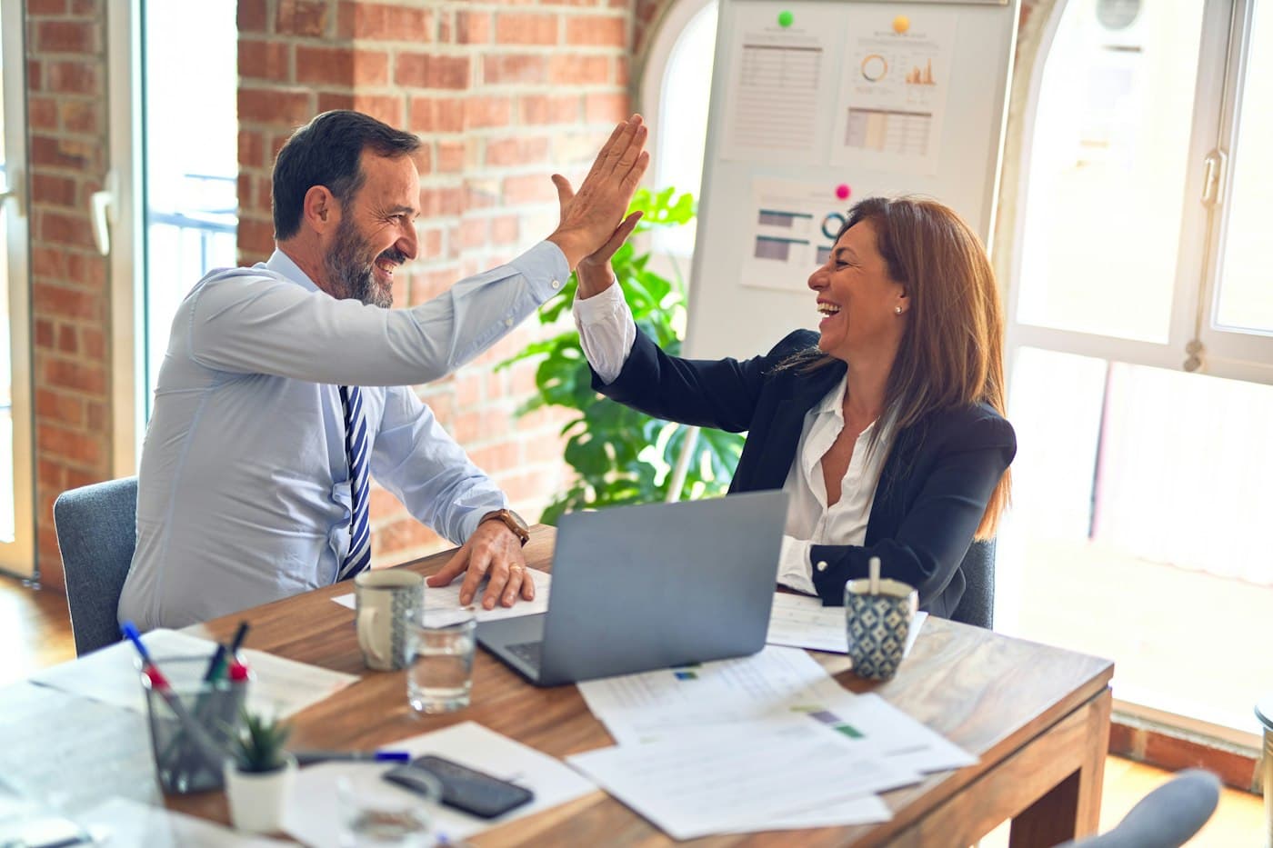 Two consultants celebrating a successful client workshop